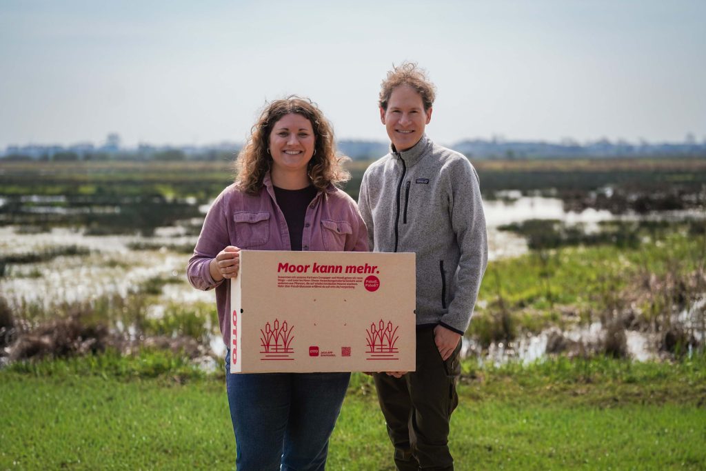 Karla Jabben und Tobias Gruber mit dem preisgekrönten Paludi-Karton von OTTO im Teufelsmoor bei Bremen.